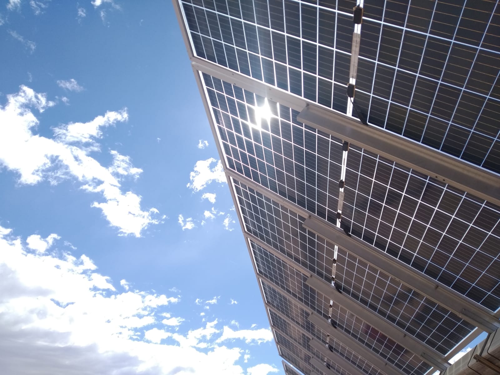 Solar panel with a solar tracker of Soltec and the sun in the background